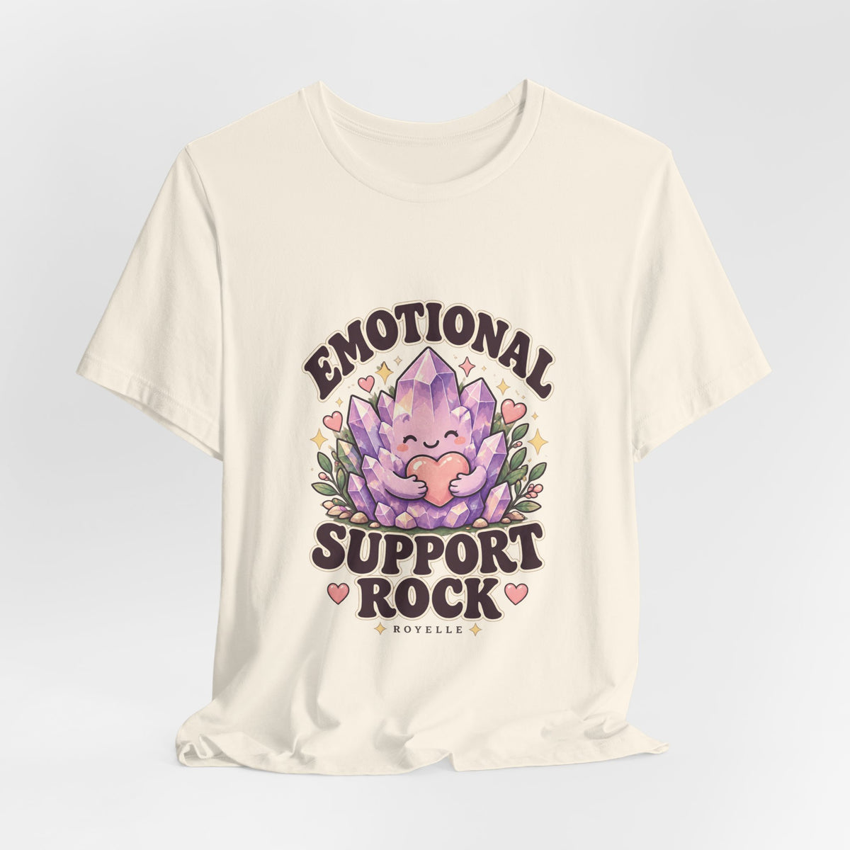 Royelle Emotional Support Rock T-shirt in Natural, hanging front view, with a smiling purple crystal hugging a pink heart and slogan.