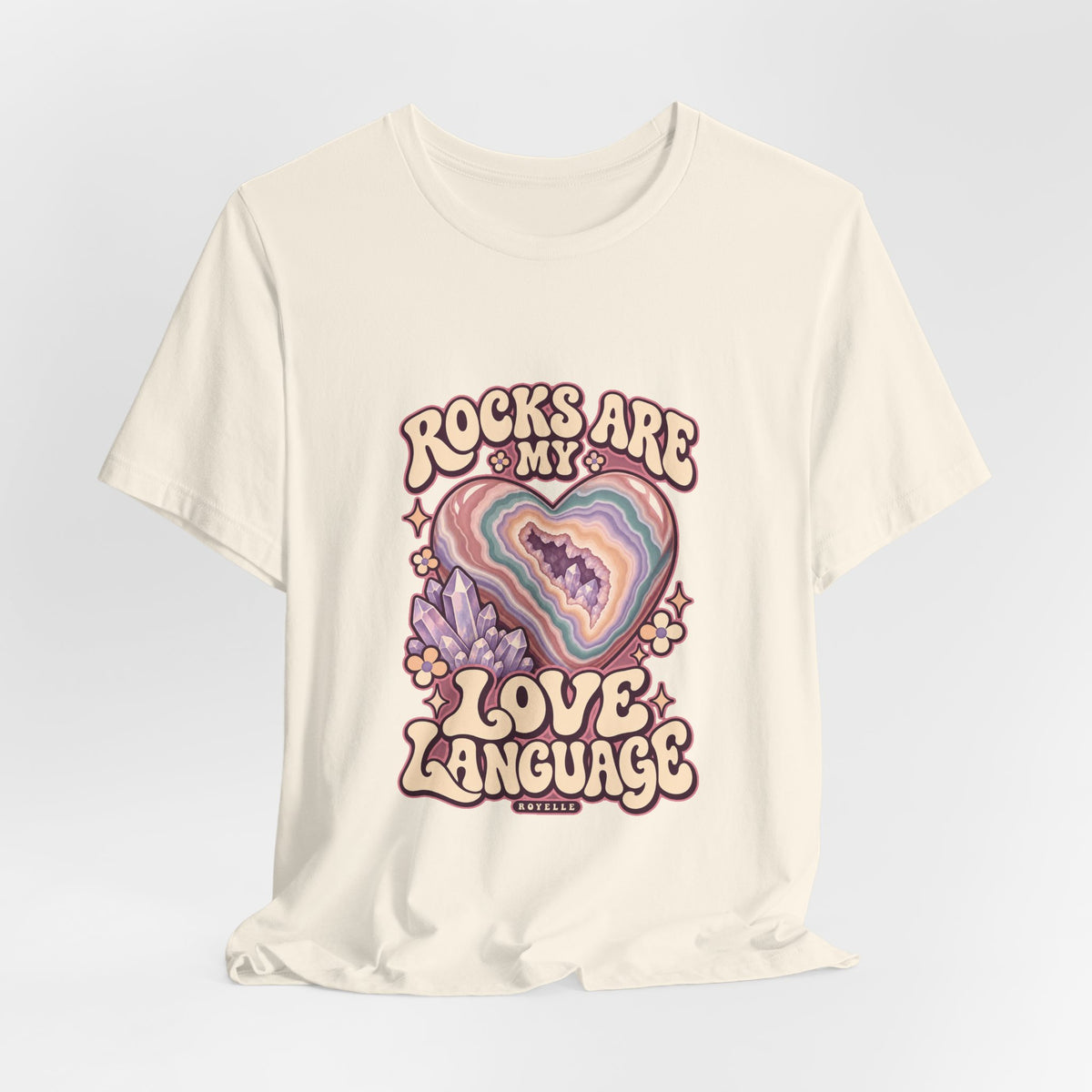 Royelle Rocks Are My Love Language T-shirt in Natural, hanging front view, with pastel agate heart, crystals and flowers and slogan.